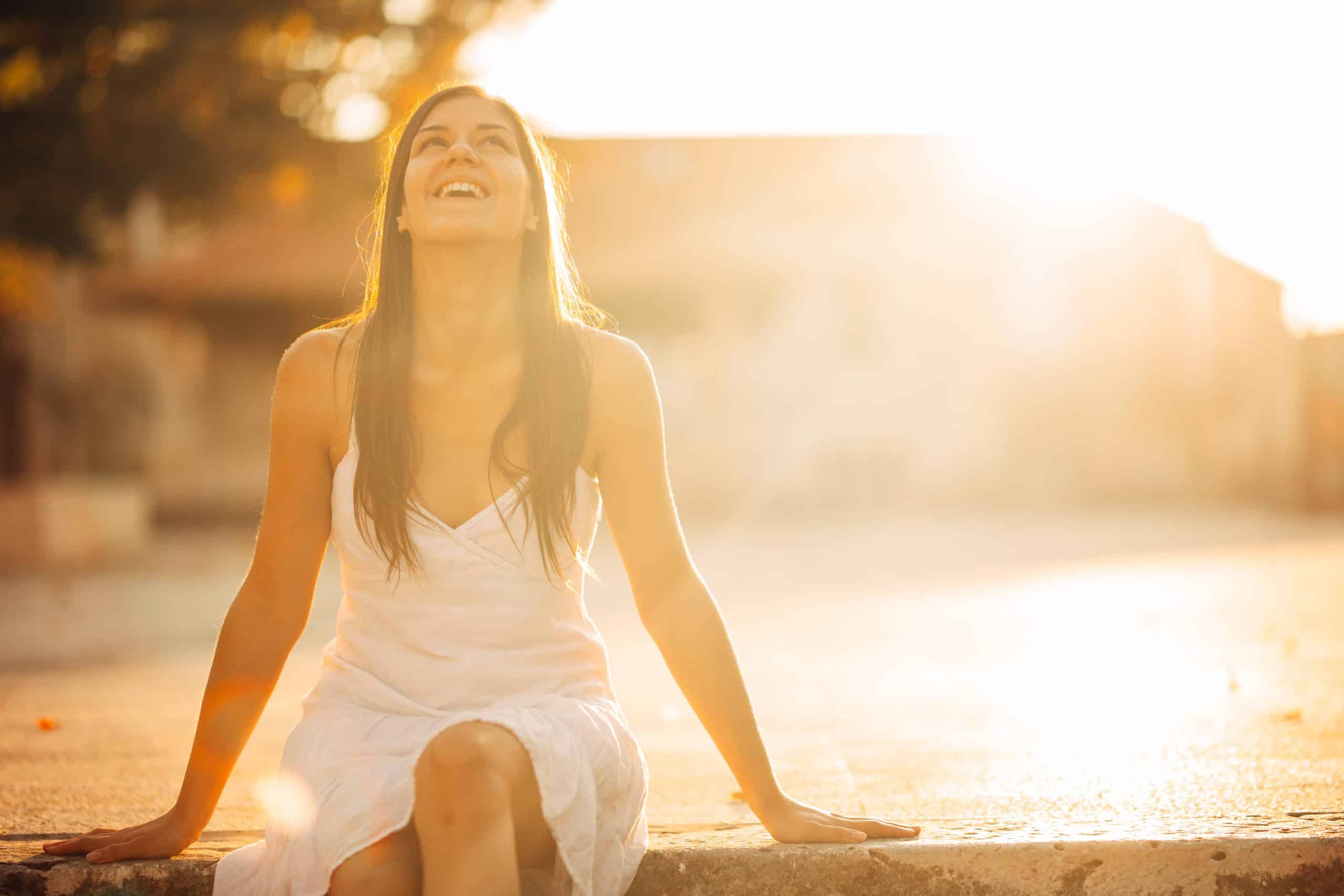 Image of woman smiling and laughing into the sun - Paul Wagner