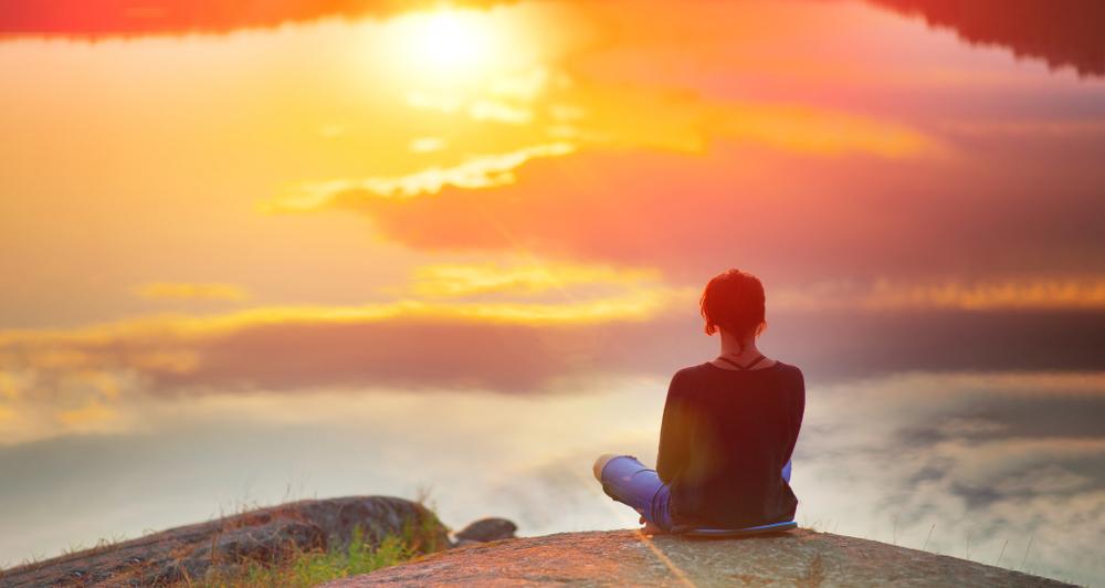 Woman looking toward sunrise symbolizing forgiveness and spirituality