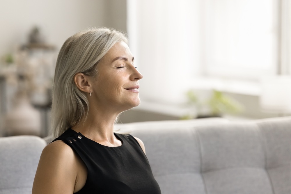 Woman with eyes closed practicing transcendental meditation using mantra technique